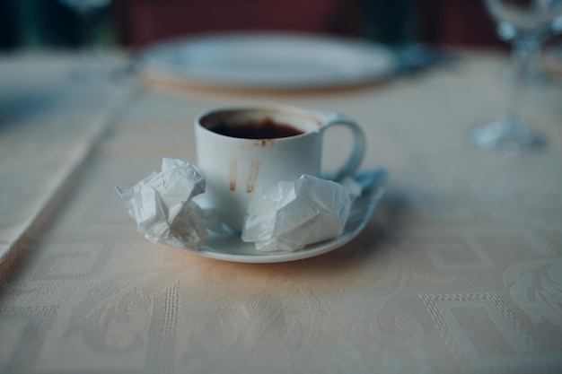 Table in cafe with empty coffee cup and napkins