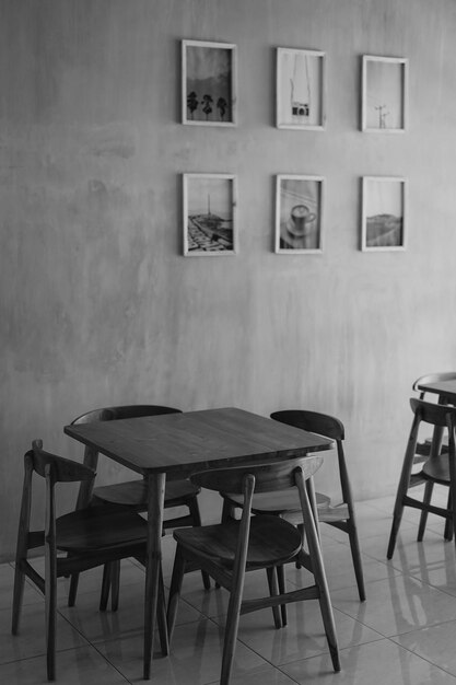 A table and chairs are in a cafe with pictures on the wall.