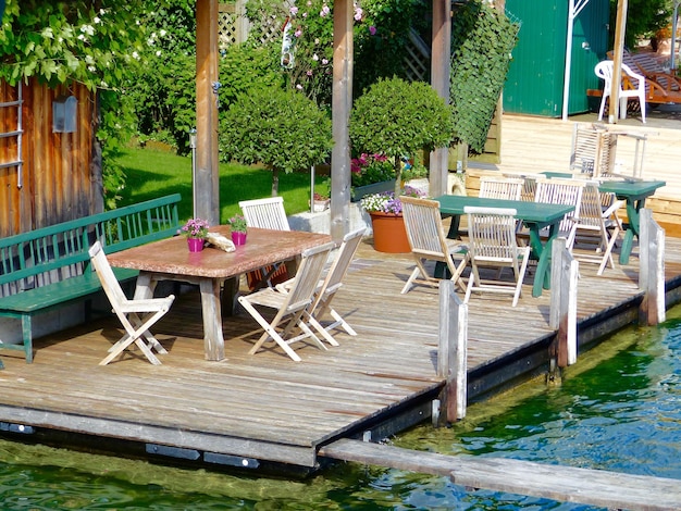 Table and chairs arranged on boardwalk by wolfgangsee lake