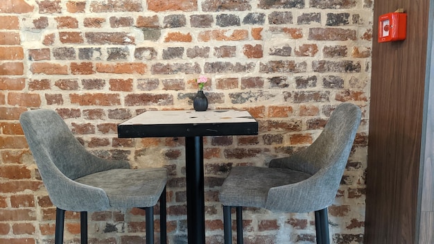 벽돌 벽의 배경에 테이블과 의자