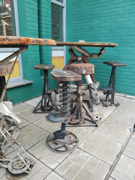 A table and chairs in cyberpunk style in front of a green building