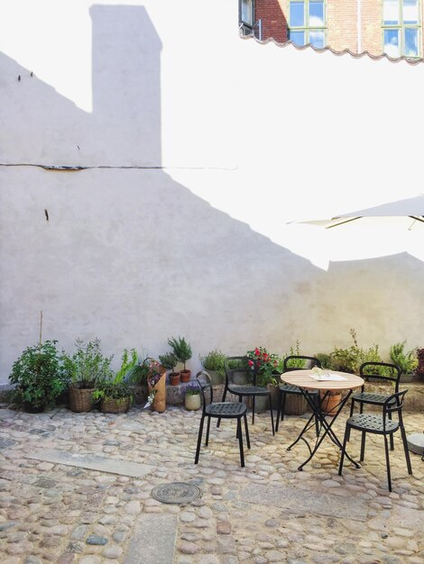 Table and chairs on paved yard of house