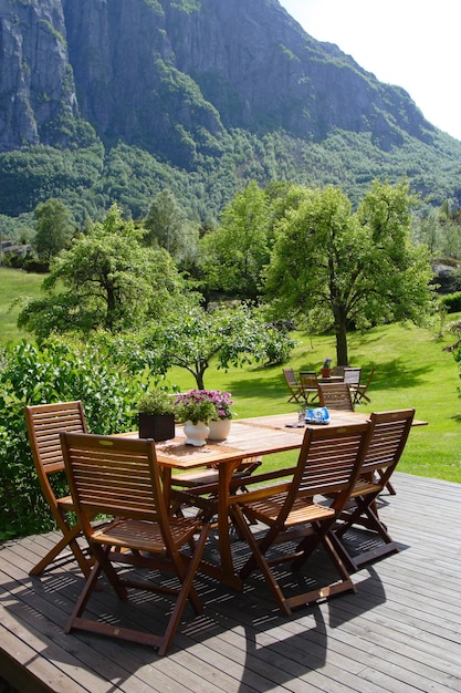 Table and chairs standing at the garden and mountains in the background