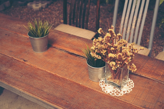 table in coffee shop with flower, vintage filter image