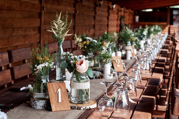 Photo table decor with white flowers and candles for a wedding party.