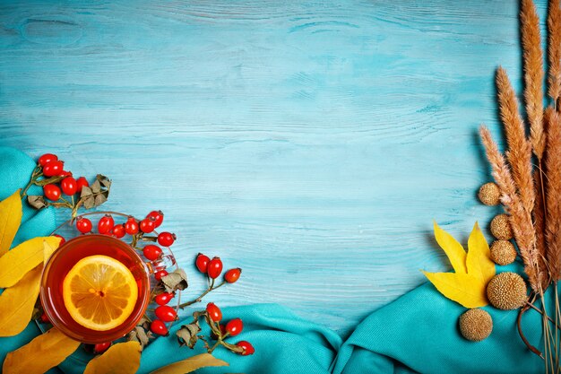 The table, decorated with autumn leaves, berries and fresh tea. Autumn. Autumn background.