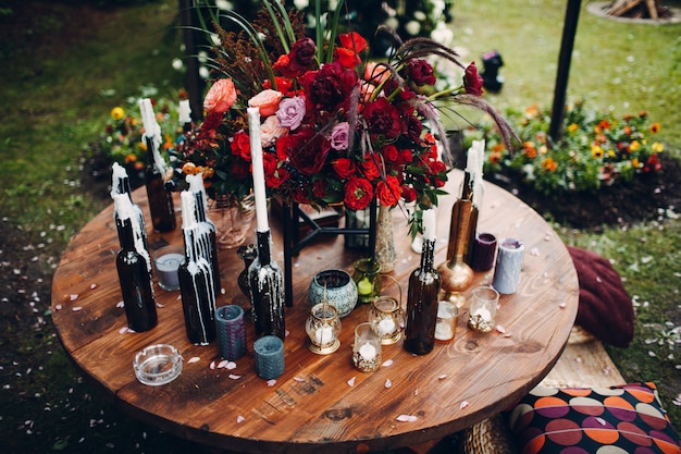 Стол, украшенный цветами и свечами в бутылке