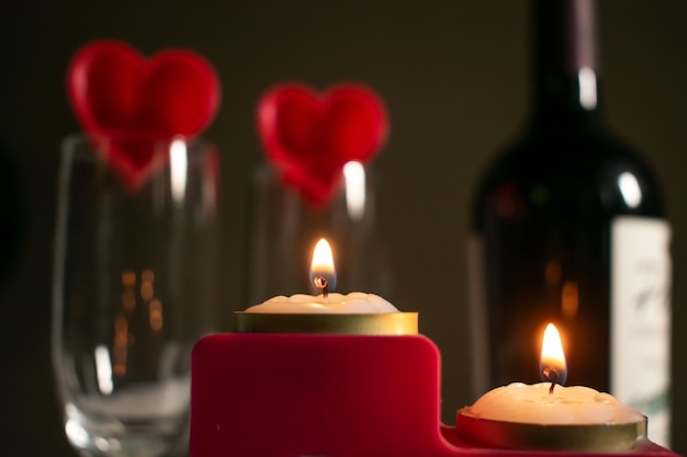 Photo table decorated with red hearts wine and candles for valentines day in february