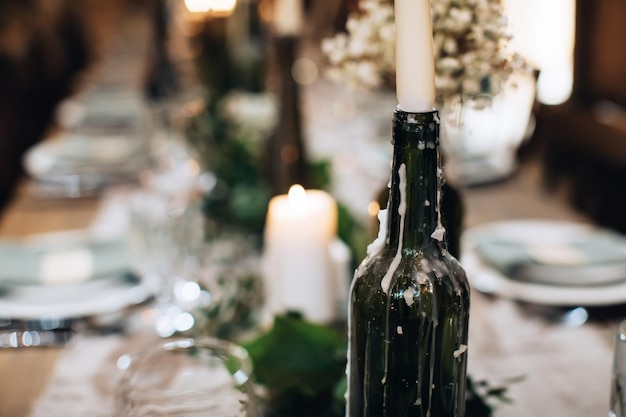 Table decoration for a festive dinner with candles in old bottles