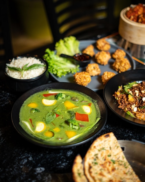 A table of food including broccoli, rice, and other food