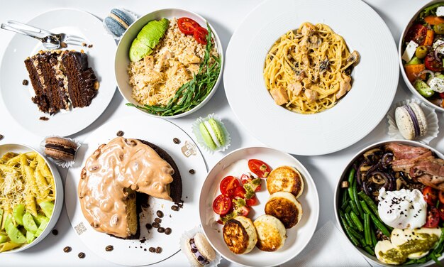 A table of food including a plate of food including a plate of food, including a plate of pasta, a plate of food, and a plate of food.