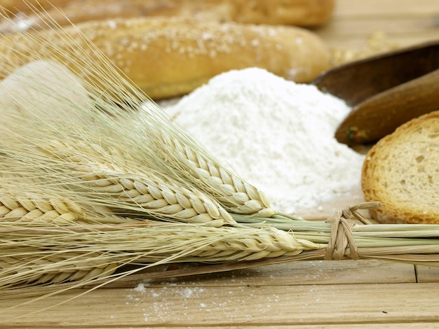 A table full of bread and flour with a bag of flour on it