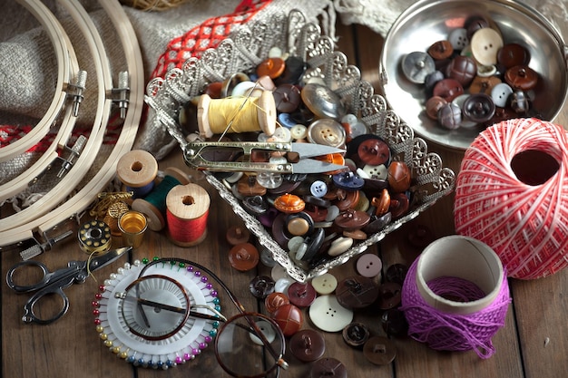 A table full of buttons and other items including a bowl of sewing supplies.