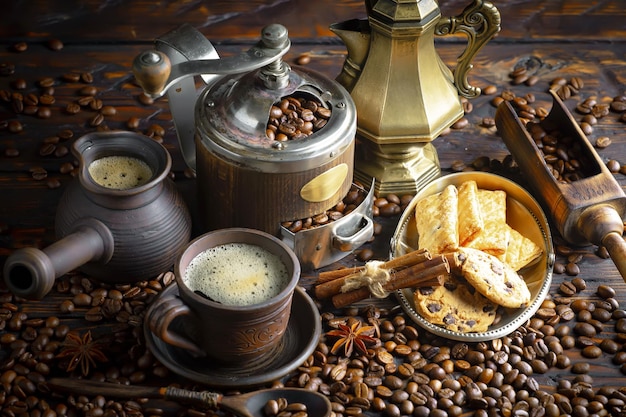 A table full of coffee and coffee cups with cinnamon sticks and a cup of coffee.