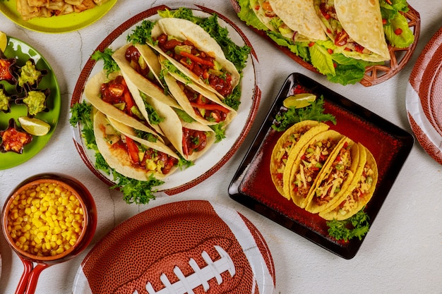 Table full of delicious snack for football game watching party. Mexican food.