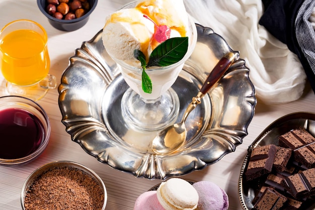 グラス一杯のアイスクリームやボウルに入ったチョコレートなどのデザートがテーブルにいっぱい。