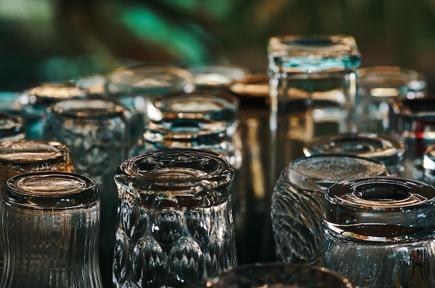 Photo a table full of empty glasses with a green background