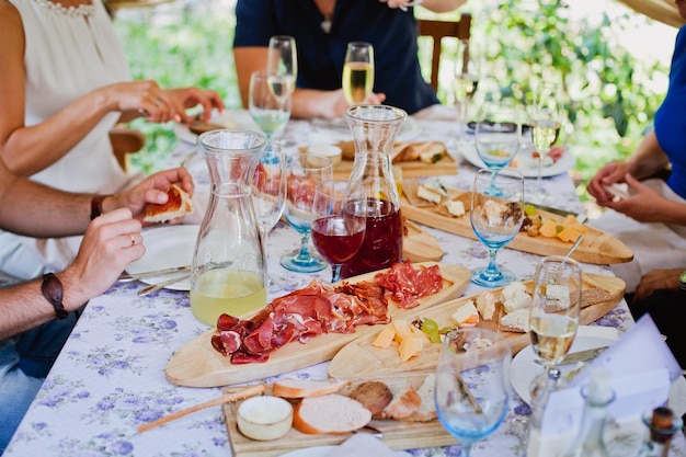 肉、チーズ、ワインなどの食べ物でいっぱいのテーブル