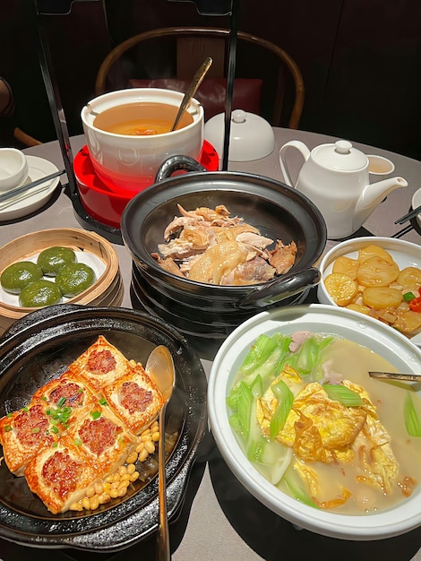 A table full of food including a plate of food and a bowl of soup.