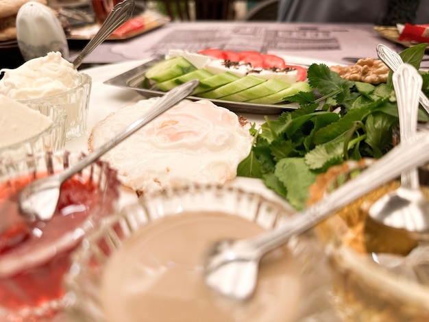 A table full of food including a plate of food with a spoon on it.