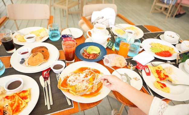 A table full of food with a person eating