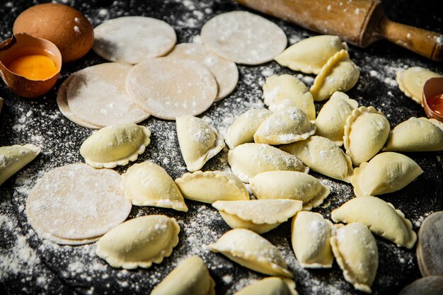 Una tavola imbandita di pasta e un mattarello con accanto un mattarello