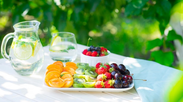 Table in the garden with fruits and lemonade