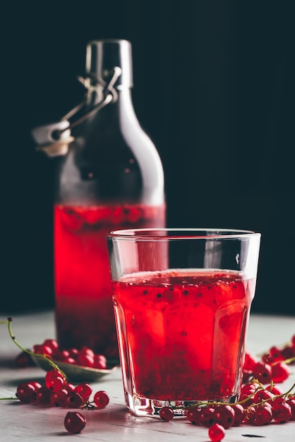 Photo table glass of infused water with fresh red currant