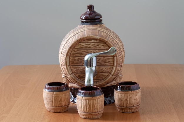 On the table is a decorative barrel with three mugs.