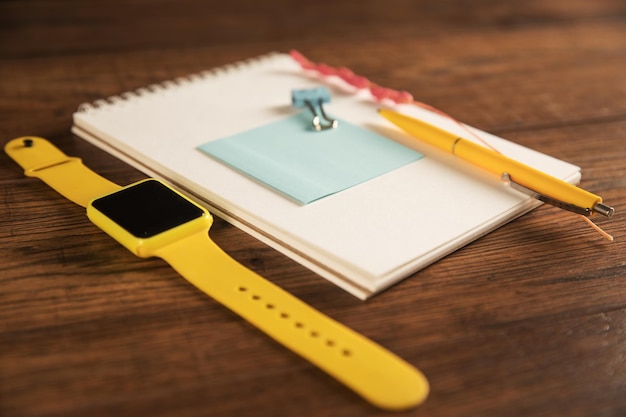on the table is an empty paper with a notepad and a clock