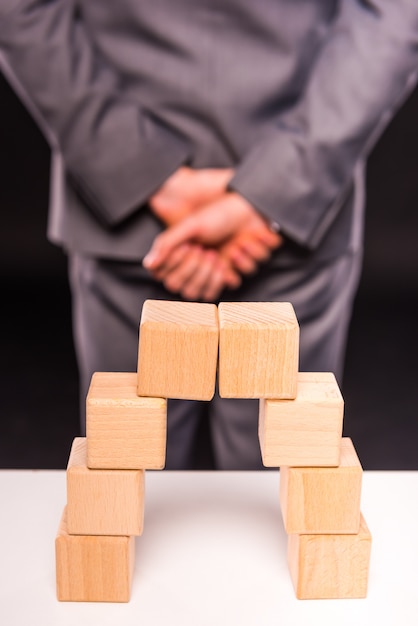 Table is figure while man turned away and folded his arms.