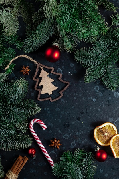 테이블 위에는 크리스마스 트리 가지 나무 장난감과 향신료로 둘러싸인 선물이 있습니다.