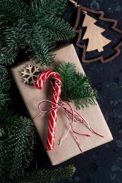 On the table is a gift surrounded by Christmas tree branches wooden toys and spices