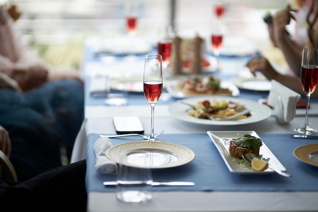 テーブルはテーブルの上にグラスに赤ワインをセットしますお祝いのテーブルセッティング