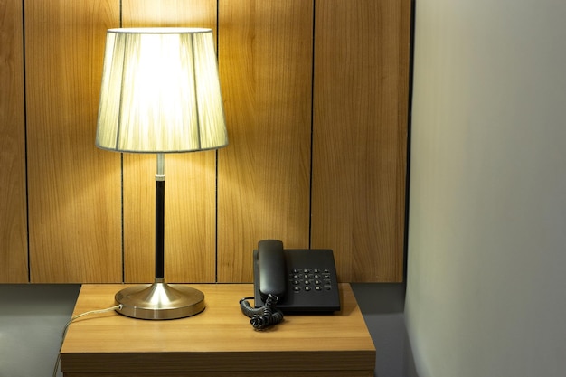 Photo table lamp and telephone on table in the bedroom