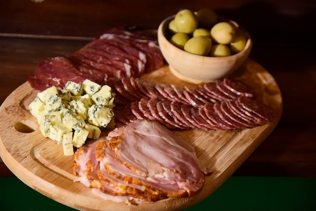 Table of olives, italian salami and cheese.