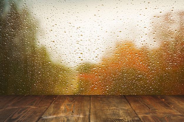 雨のウィンドウの背景上のテーブル