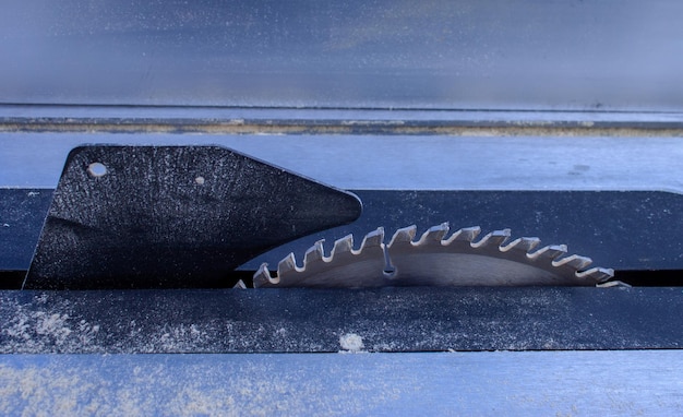 Table saw on metal table and wooden chips on it