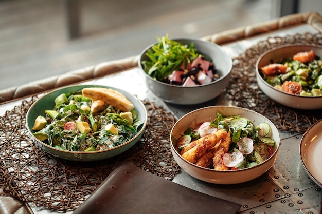 Table served with different gourmet salad bowls