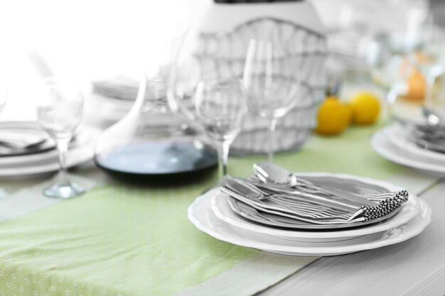 Фото Сервированный стол с посудой и серебряными приборами