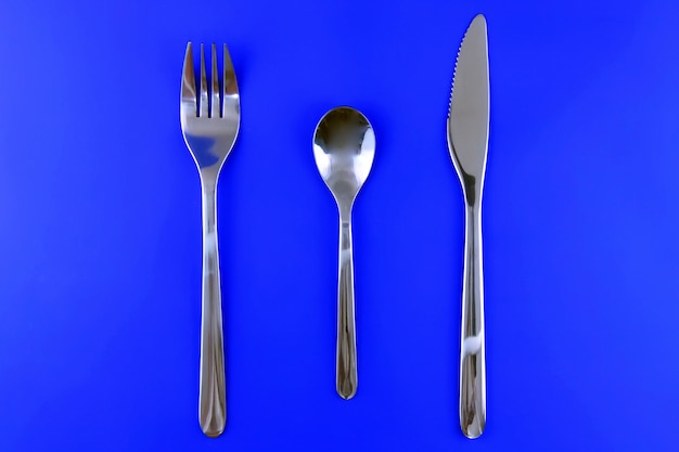 Table serving-knife,plate,fork on  various colour background.