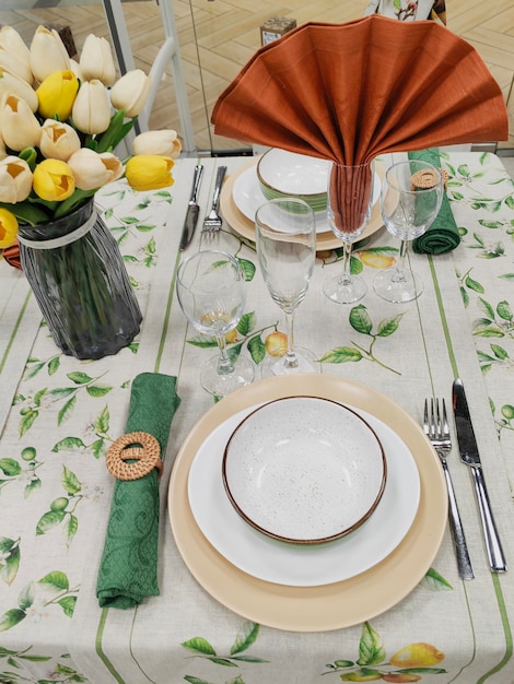 Photo a table set for a dinner with a vase of roses on the table.