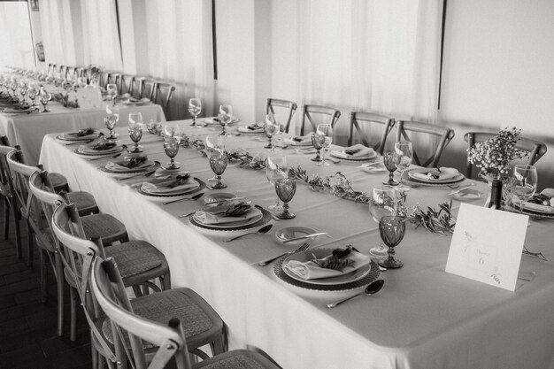 A table set for a wedding reception with a white tablecloth and a sign that says'the word dinner'on it