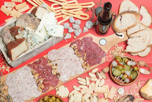 table set with an aperitif consisting of different foods cheeses and cans of pickles