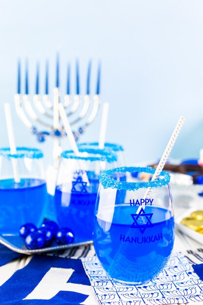 Photo table set with cocktails and chocolates to celebrate hanukkah.