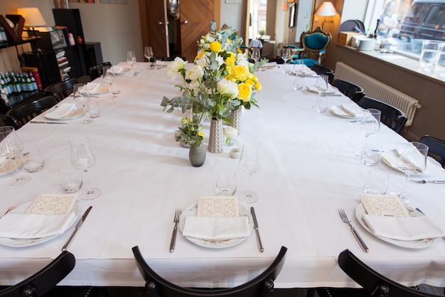 Table set with yellow roses for a festive party