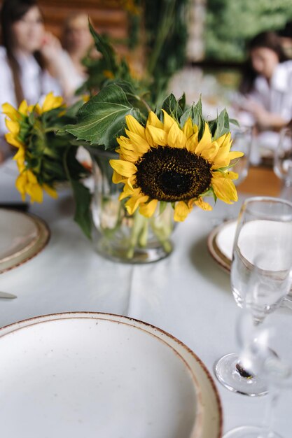 Сервировка стола, красивые белые тарелки, серебряные столовые приборы и хрустальные бокалы, застолье на открытом воздухе в праздник