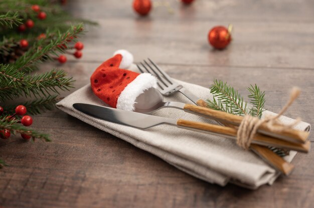 Table setting Christmas decorationsFir branches and cutlery Santa hatChristmas serving cutlery