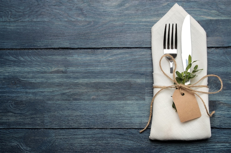 Photo table setting. cutlery. fork, knife in a white napkin on a blue wooden table. top view