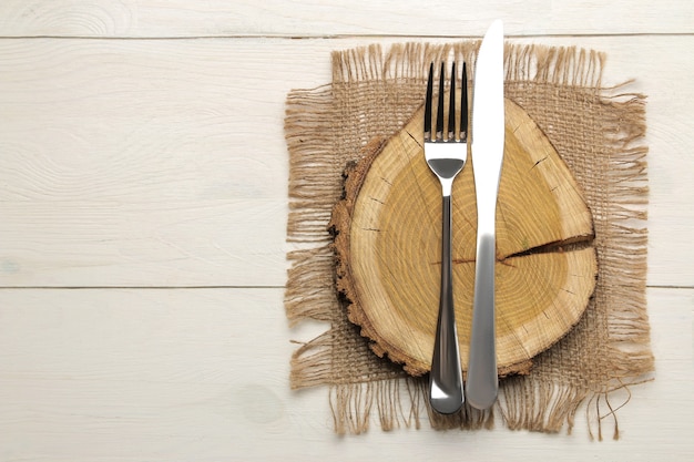 Photo table setting. cutlery. fork, knife and wooden stand on a white wooden table. top view